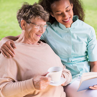 a caregiver sitting next to an elderly person